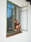 Ragazze che guardano attraverso la finestra aperta, ritratto — Foto stock
