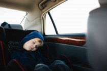 Мальчик спит на заднем сиденье машины — стоковое фото