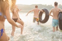 Amigos que se divertem com anel inflável no rio — Fotografia de Stock