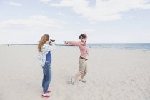 Fotografia de casal com câmera instantânea na praia — Fotografia de Stock