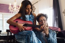 Nonna insegna nipote a suonare la chitarra — Foto stock
