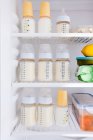 Bottles of breast milk in refrigerator — Stock Photo
