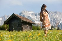 Mujer en el prado con Alpes bávaros en el fondo, Alemania - foto de stock