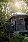 Mother and daughter standing outside wooden cabin — Stock Photo