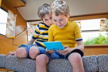 Two boys playing handheld video game — Stock Photo