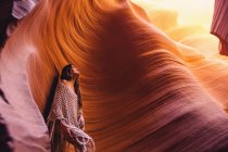 Женщина смотрит на солнечный свет в пещере, Каньон Антилопы, Пейдж, Аризона, США — стоковое фото