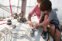 Father and son on board yacht with rope — Stock Photo