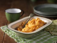 Dish of mashed sweet potatoes with spoon — Stock Photo