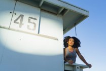 Mitte erwachsene Frau steht auf Aussichtsturm am Strand, Blick auf Aussicht — Stockfoto