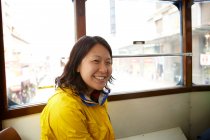 Портрет усміхненої азіатки в трамваї — стокове фото