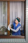 Femme époussetant cadres de fenêtre — Photo de stock