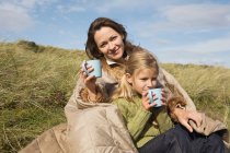 Mother and daughter outdoors with drinks — Stock Photo