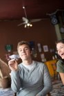 Young man holding paper airplane in coffee house — Stock Photo