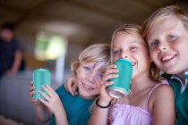 Crianças bebendo refrigerante na garagem — Fotografia de Stock