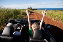 Women driving convertible on dirt road — Stock Photo