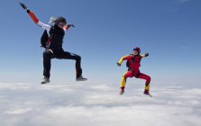 Las mujeres paracaidismo sobre nubes - foto de stock