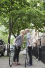 Jovem casal com bicicletas beijando na rua — Fotografia de Stock