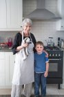 Портрет бабушки и внука на кухне — стоковое фото