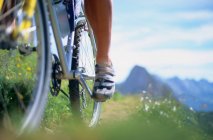 Primer plano de un pie ciclista y rueda de bicicleta - foto de stock
