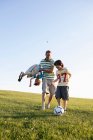 Padre y niños jugando al fútbol - foto de stock