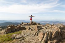 Молода жінка стоїть на скелі, дивлячись на гору Срібної Зірки, Вашингтон, США. — стокове фото