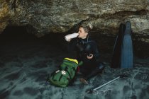 Mergulhador com espingarda descansando na praia, Big Sur, Califórnia, EUA — Fotografia de Stock