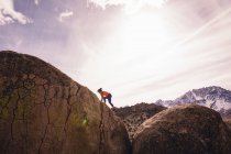 Donna arrampicata su roccia, Buttermilk Boulders, Bishop, California, USA — Foto stock