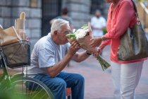 Cape Town, South Africa, elderly man smelling a bunch of flowers — Stock Photo
