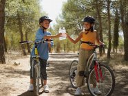 Menino e menina em bicicletas com garrafas de água — Fotografia de Stock