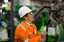 Ingenieur inspiziert Maschinen in Fabrik — Stockfoto