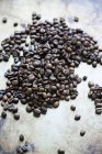 Pile de grains de café torréfiés sur le comptoir de la cuisine — Photo de stock
