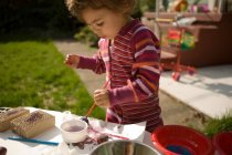 Toddler girl playing with paints outside — Stock Photo