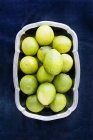 Key limes in a metal bowl, top view — Stock Photo