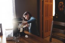 Junges Mädchen gießt Zutaten in Schüssel mit Mixer — Stockfoto