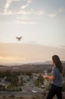 Operadora comercial fêmea voando drone acima do desenvolvimento habitacional, Santa Clarita, Califórnia, EUA — Fotografia de Stock