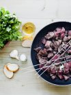 Skewers and meat cooking in pan — Stock Photo