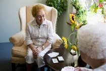 Две зрелые женщины играют в карты вместе — стоковое фото
