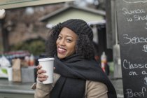 Ritratto della donna che prende il caffè godendo la città durante le vacanze invernali dal caffè all'aperto — Foto stock