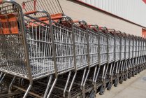 Diminishing perspective view of shopping trolleys row — Stock Photo