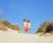 Chicos gemelos en una duna de arena - foto de stock