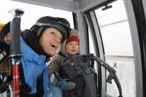 Mother and child riding ski lift — Stock Photo