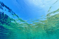 Superficie dell'acqua ondulata con cielo blu visto dal basso — Foto stock