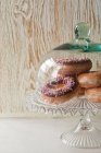 Donuts sob frasco de vidro — Fotografia de Stock