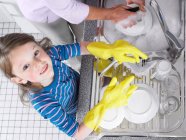 Menina ajudando com lavar a louça — Fotografia de Stock