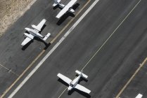 Vista aérea de tres aviones en la pista del aeropuerto - foto de stock
