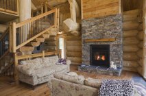 Chimney place in living room of Eastern white pine log cabin — Stock Photo