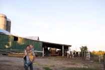 Paar auf Bauernhof, Mann trägt Frau auf dem Rücken — Stockfoto