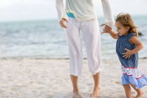Girl and mother on beach — Stock Photo