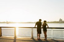 Coppia di jogging in piedi sul lungofiume — Foto stock