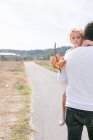 Vue arrière de l'homme mature portant sa fille sur la côte — Photo de stock